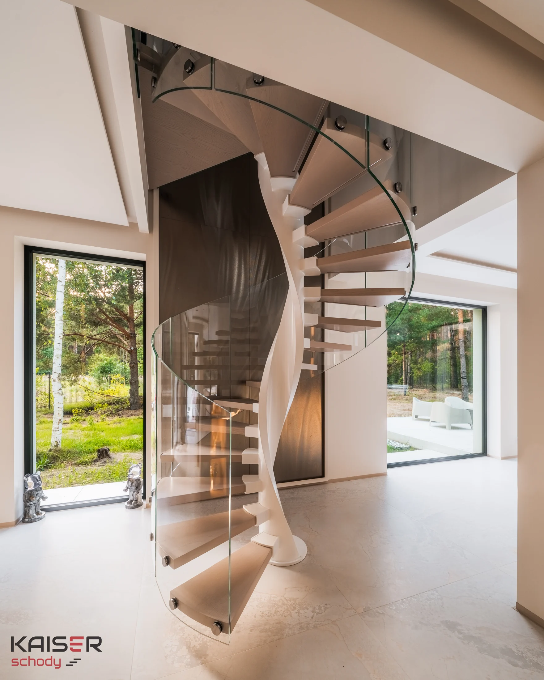 Jasne schody spiralne KAISER ze szklaną balustradą we wnętrzu
